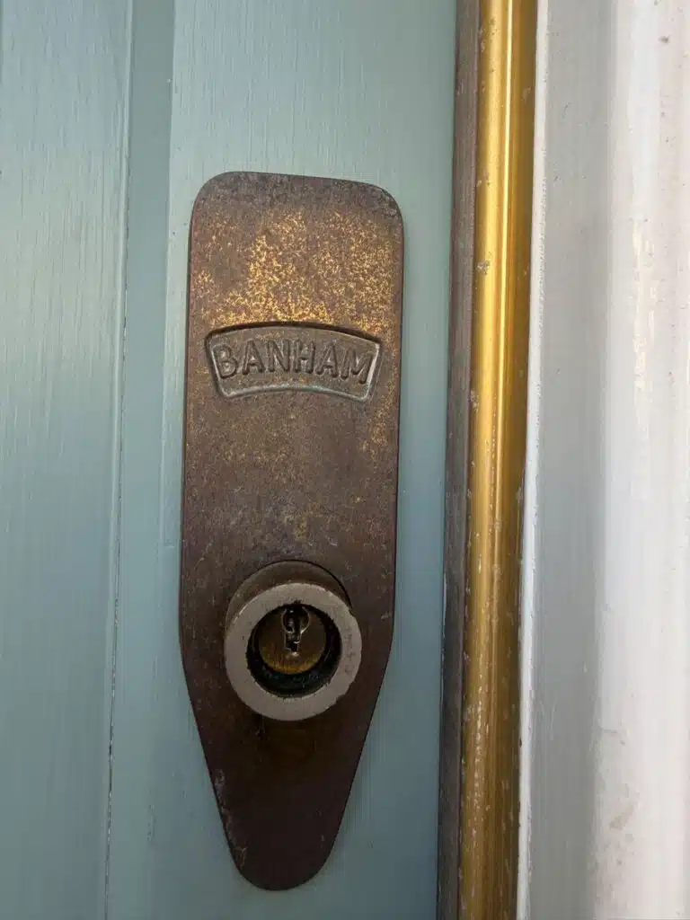 Old worn Banham lock fitted on pale blue front door