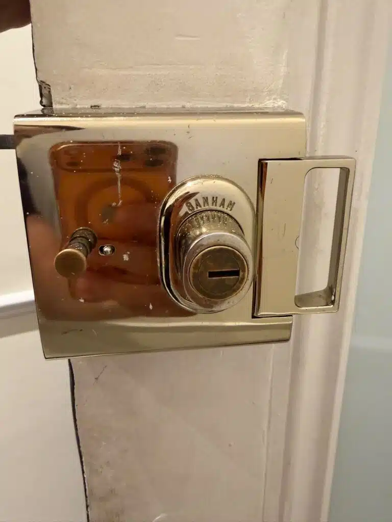 Brass Banham nightlatch lock fitted on white front door