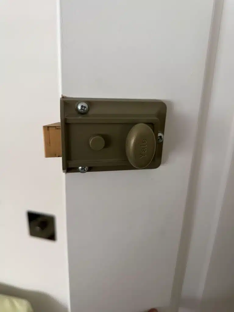 Yale nightlatch lock fitted on white front door