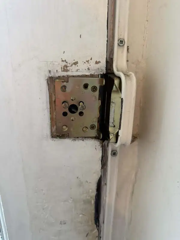 Worn night latch removed from a timber door in Battersea, showing the mounting plate before replacement